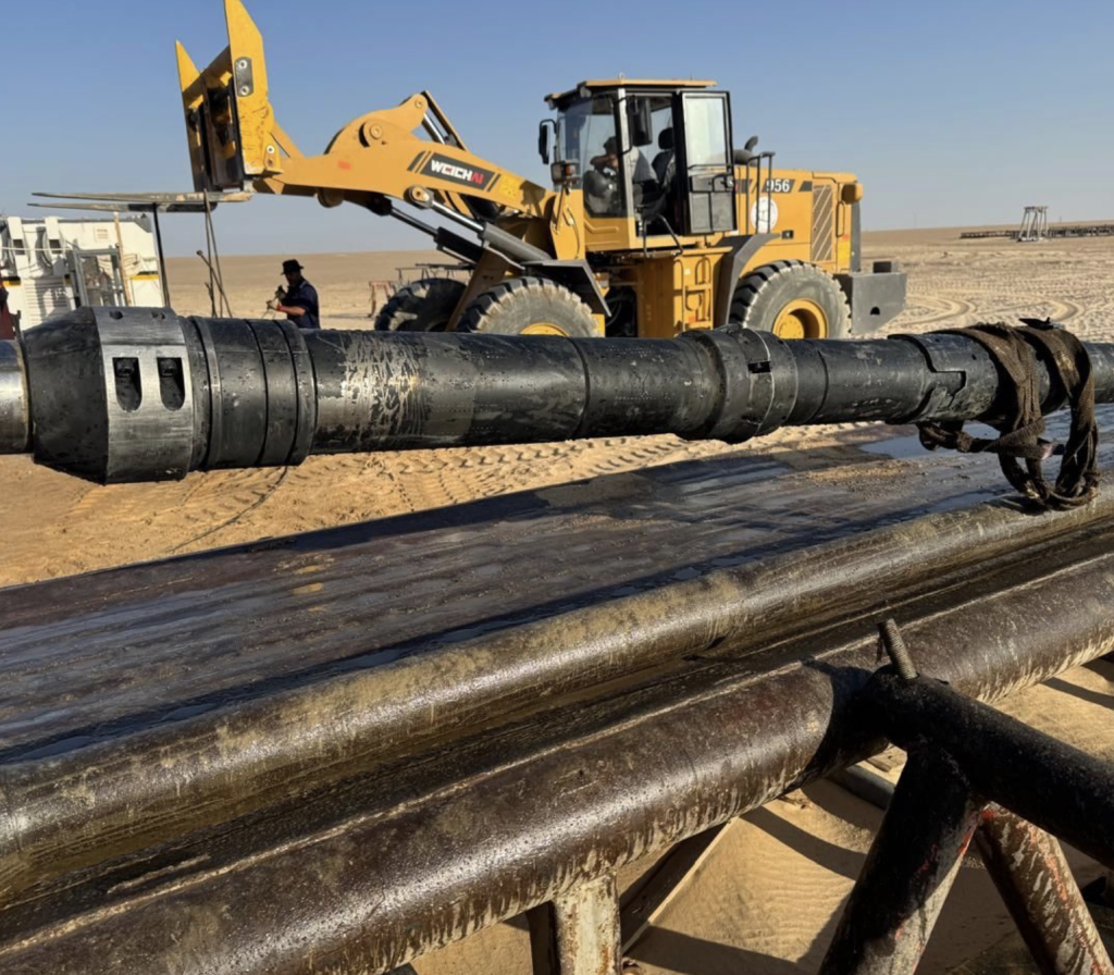 LDC completions team preparing a large liner hanger component for deployment in a complex well in a desert oilfield, showcasing the heavy equipment and precision involved in challenging operations.
